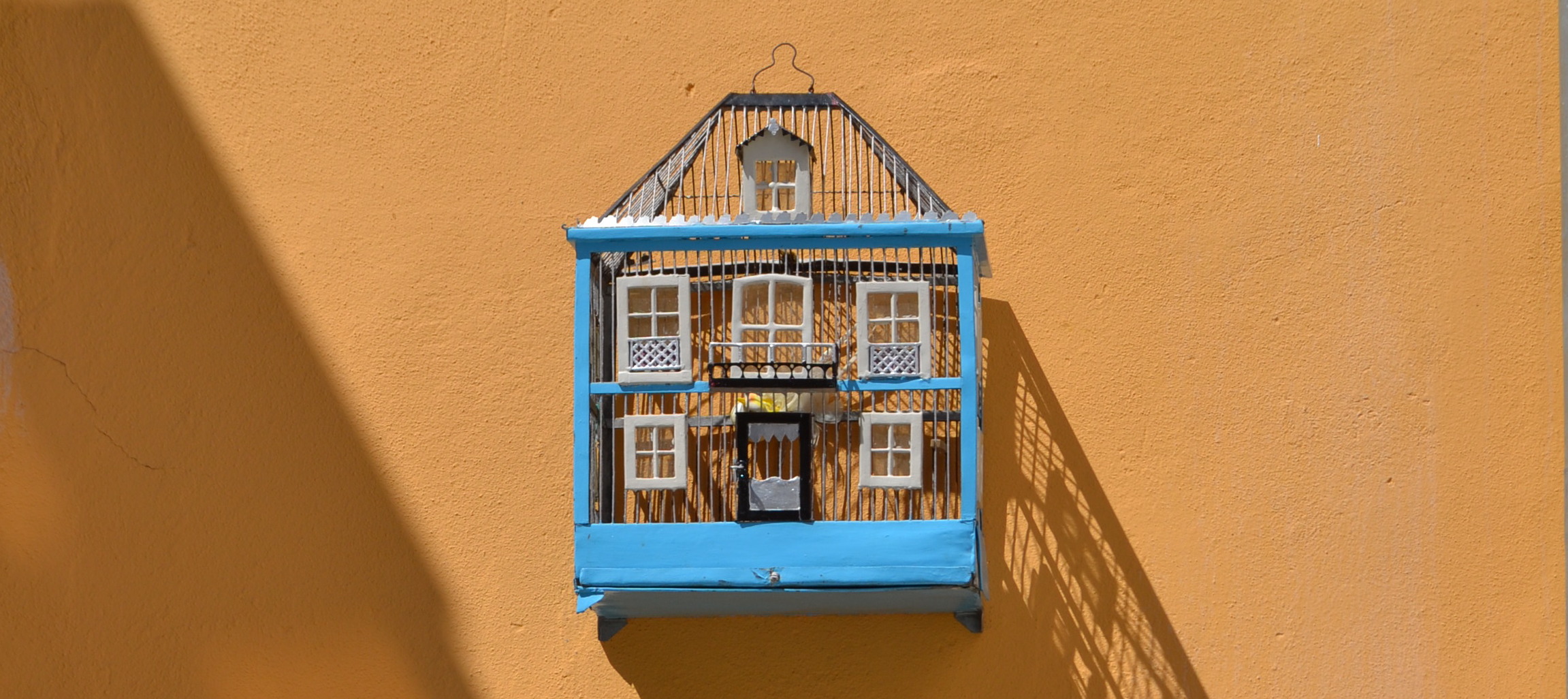 a bird's cage on a wall